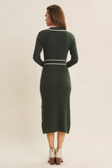 woman wearing a dark green ribbed midi dress with long sleeves and a white belt detail, shown from the back