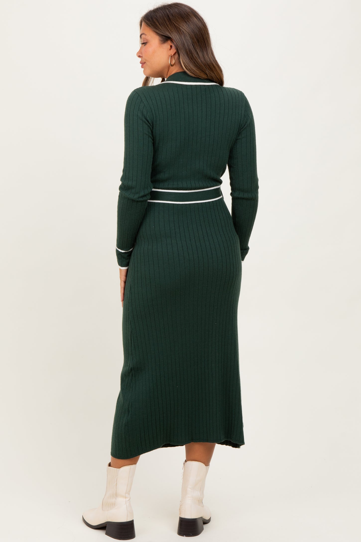 woman wearing a dark green ribbed maternity dress with a white stripe detail and long sleeves, showing her baby bump from the back