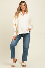 woman wearing a cream maternity pullover sweatshirt with a collar and relaxed fit, paired with jeans and sandals