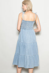 woman wearing a light blue tiered midi dress with smocked bodice and adjustable tie straps