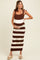 woman wearing a brown and cream striped maternity dress with ruffle straps and holding her baby bump