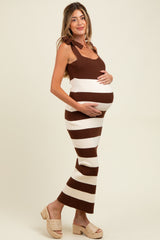woman wearing a brown and white striped maternity dress with tie straps, gently cradling her baby bump