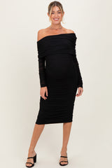 woman wearing a black off-the-shoulder maternity dress with ruching and a visible baby bump