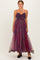 woman wearing a plum and floral maxi dress with spaghetti straps and a fitted bodice, standing in a flowy tulle skirt