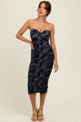 woman wearing a navy blue strapless bodycon dress with ruching details and a sweetheart neckline