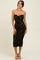 woman wearing a strapless olive green bodycon midi dress with ruching details and high slit
