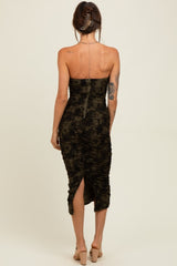 woman wearing a black and olive green ruched strapless midi dress with a slit at the back