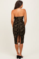 woman wearing a dark green strapless ruched maternity dress with a slit at the back
