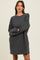 woman wearing a charcoal gray oversized sweatshirt dress with long sleeves and a relaxed fit