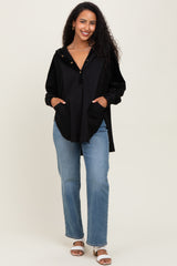 woman wearing a black maternity hoodie with pockets and button detail, paired with light wash jeans and sandals