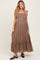 woman wearing a brown striped maxi maternity dress with a square neckline and tie straps, showing a visible baby bump