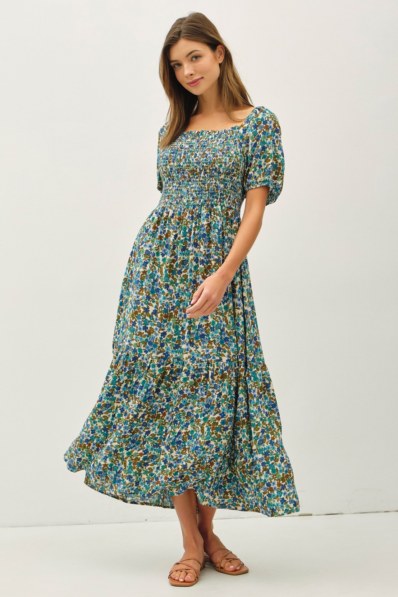 woman wearing a blue floral maxi dress with puff sleeves and a smocked bodice