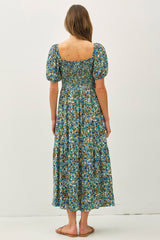 woman wearing a floral print maxi dress with puff sleeves and a smocked bodice, seen from the back