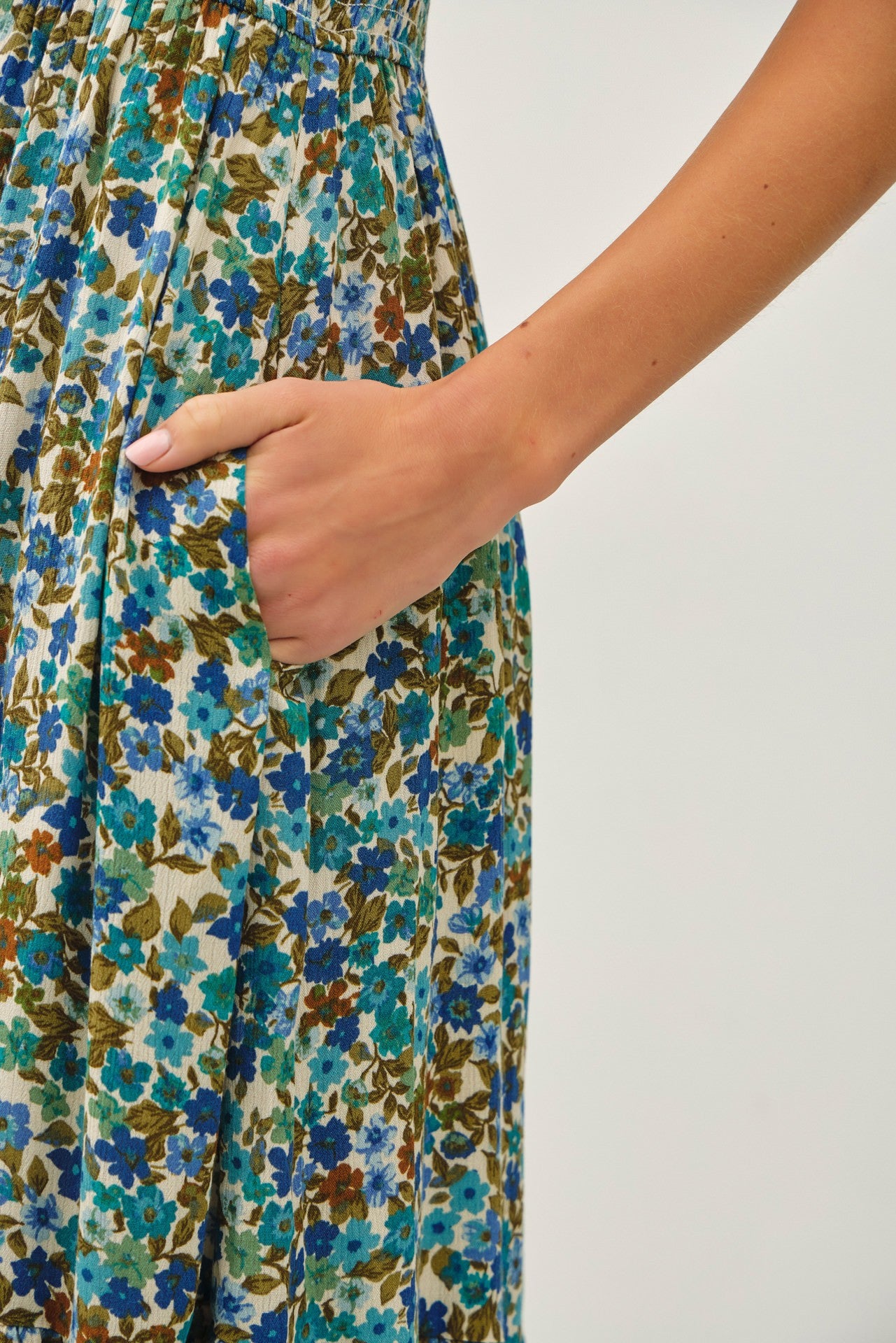 woman wearing a floral maxi dress with a gathered waist and pockets