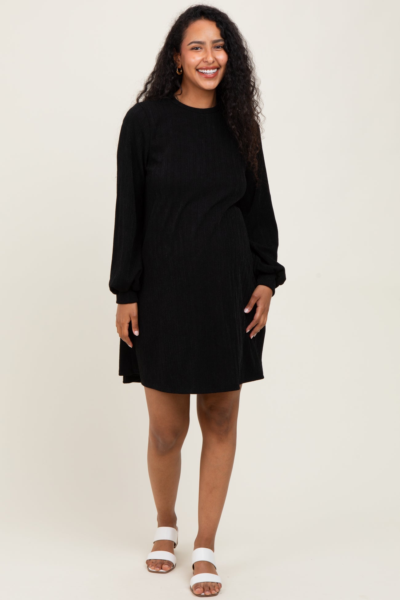 woman wearing a black long sleeve maternity dress with ribbed texture and loose fit, showcasing her baby bump