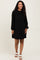 woman wearing a black long sleeve maternity dress with ribbed texture and loose fit, showcasing her baby bump