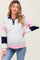 woman wearing a gray maternity pullover sweatshirt with pink and navy color block design and a visible baby bump