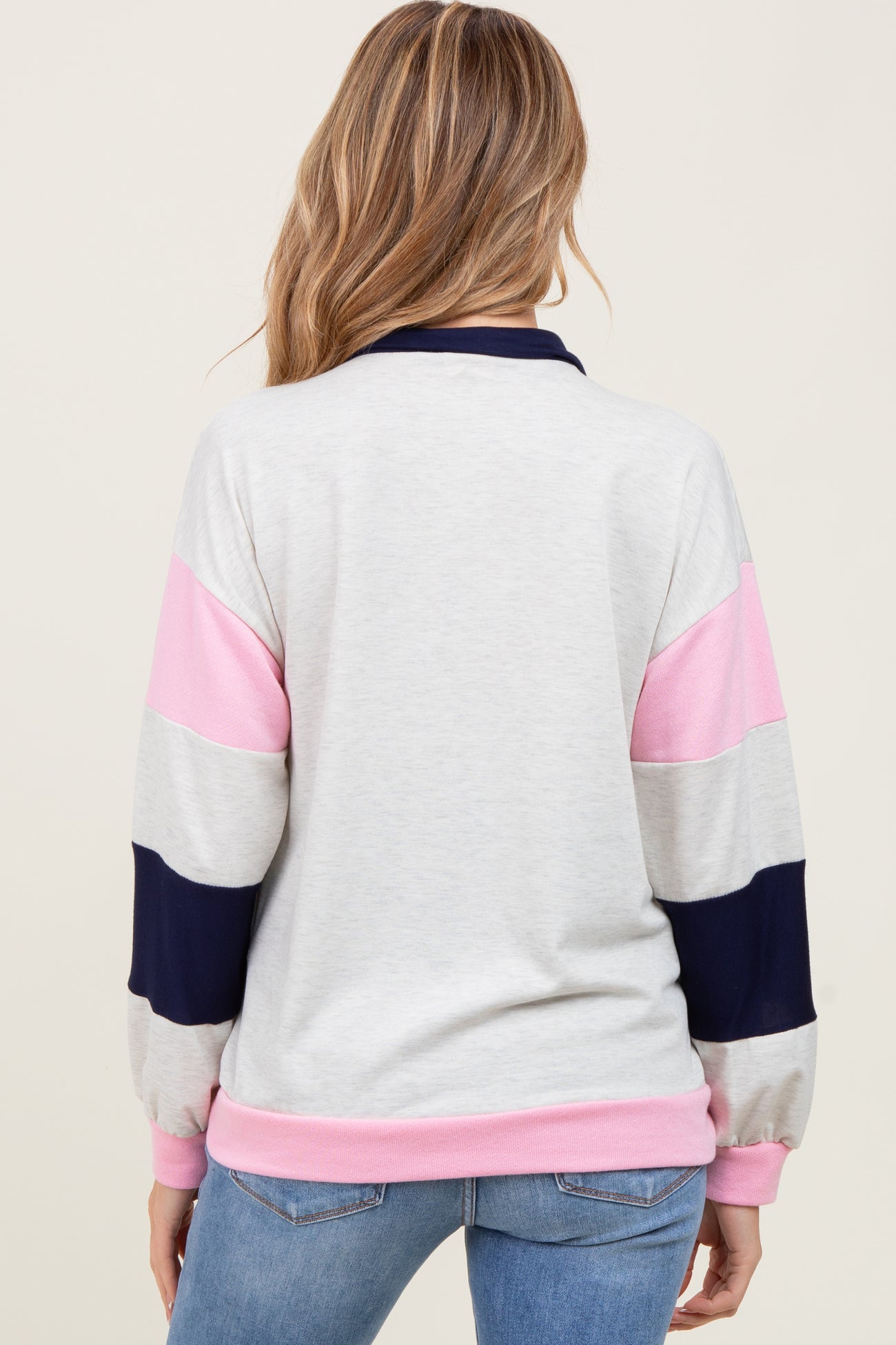 woman wearing a color-blocked gray, pink, and navy long sleeve maternity top viewed from the back