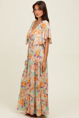 woman wearing a colorful floral maxi dress with a deep v-neck and flutter sleeves