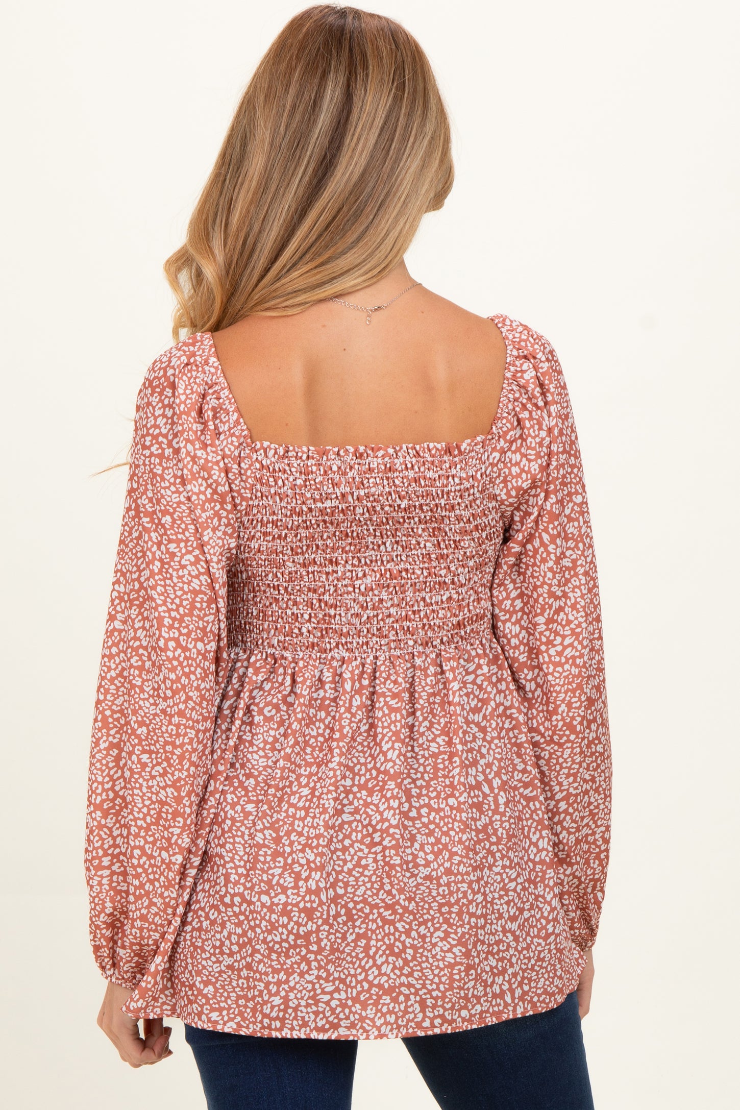 woman wearing a mauve floral maternity blouse with a square neckline and smocked back detail