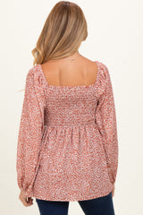 woman wearing a mauve floral maternity blouse with a square neckline and smocked back detail