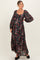 woman wearing a dark floral maternity maxi dress with long sleeves and a visible baby bump