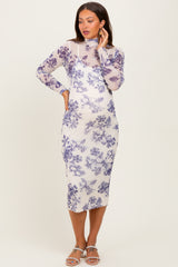 woman wearing a floral print maternity dress with long sleeves and a fitted silhouette, showing her baby bump