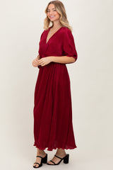 woman wearing a burgundy maxi dress with short sleeves and a v-neckline, styled with black heeled sandals