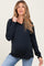 woman wearing a black long sleeve maternity polo shirt and showing her baby bump