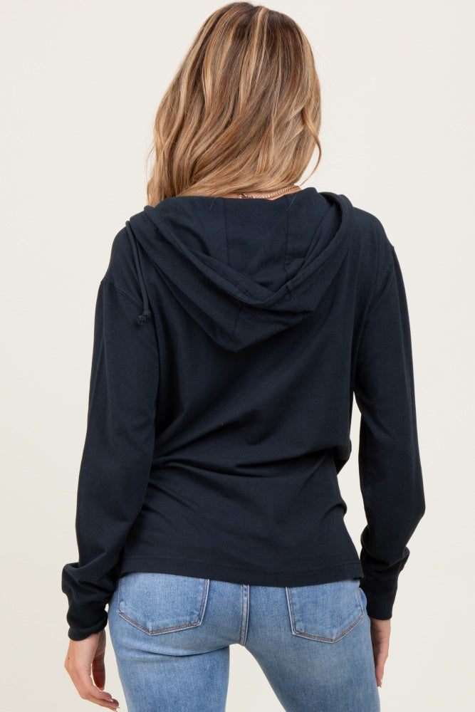 woman wearing a navy blue maternity hoodie with a relaxed fit and drawstring hood, facing away from the camera
