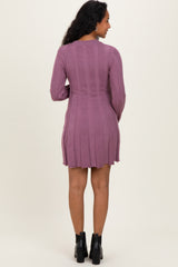 woman wearing a mauve ribbed long sleeve maternity dress, shown from the back