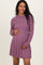 woman wearing a ribbed purple long sleeve maternity dress and holding her baby bump