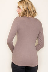 woman wearing a taupe long sleeve ribbed top, viewed from the back, styled with black pants
