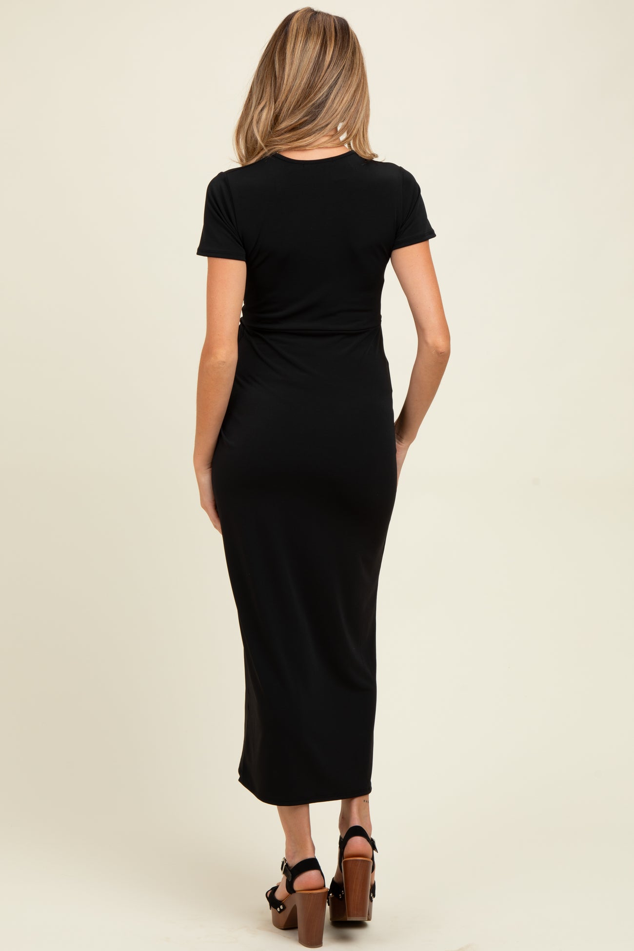 woman wearing a black short sleeve maternity maxi dress, showing the back view