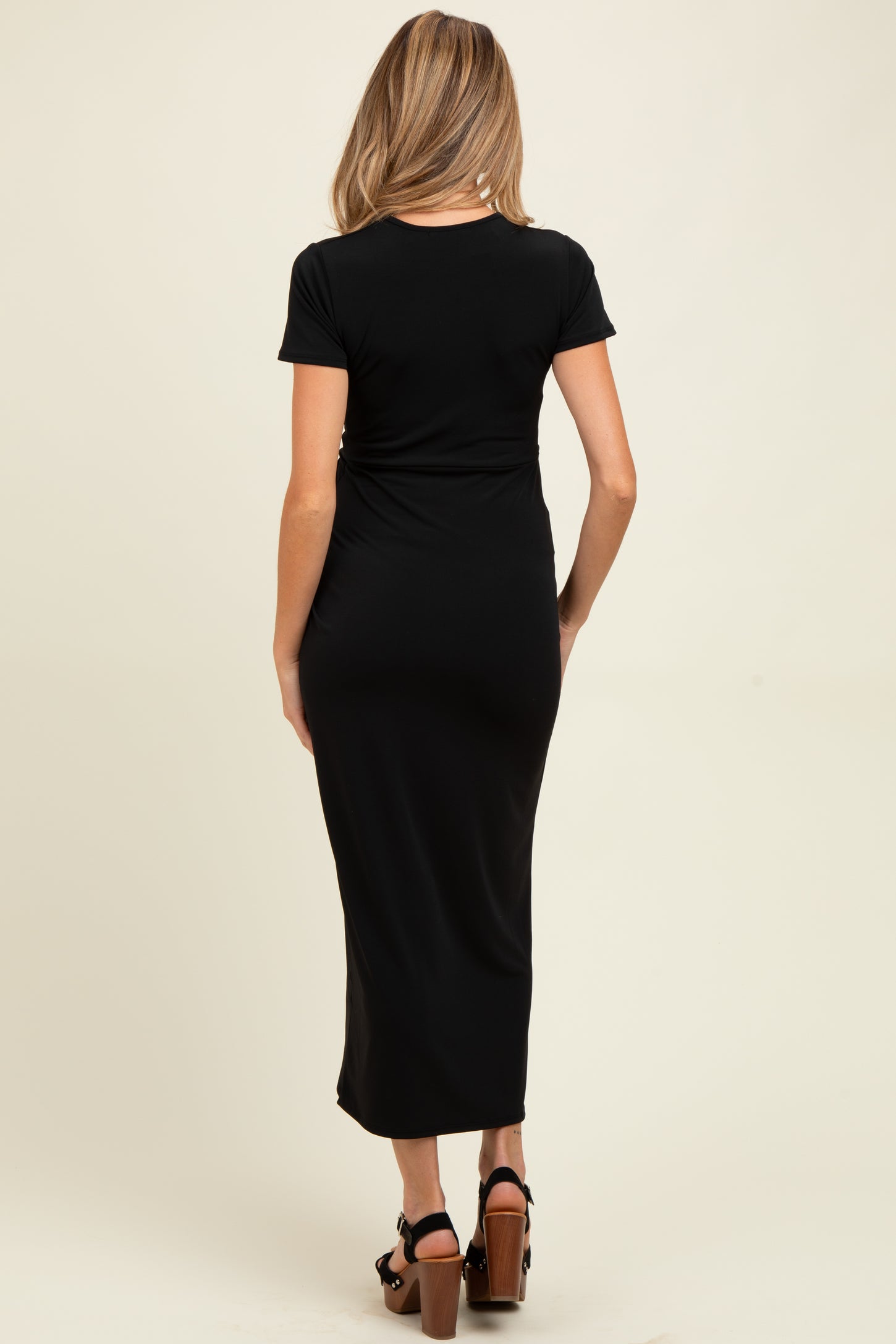 woman wearing a black short sleeve maternity maxi dress, showing the back view