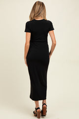 woman wearing a black short sleeve maternity maxi dress, showing the back view