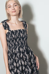 woman wearing a black floral smocked sundress with tie shoulder straps