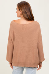 woman wearing a light brown oversized ribbed sweater, showing the back view and soft open neckline