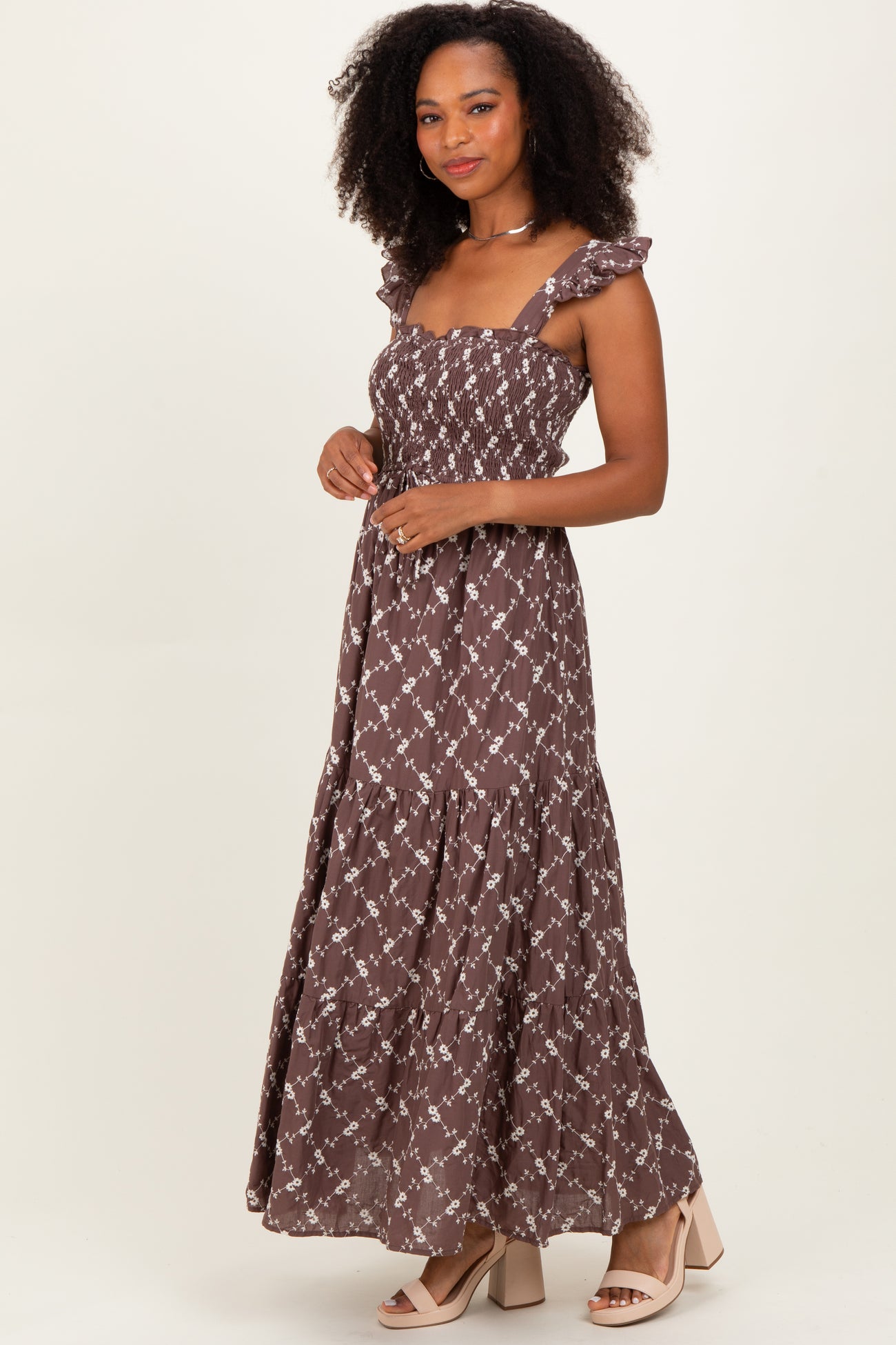 woman wearing a brown floral maxi dress with smocked bodice and ruffled straps