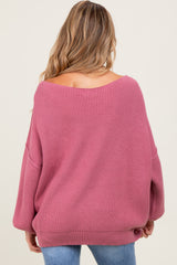 woman wearing a soft pink oversized maternity sweater with a wide neckline and long sleeves