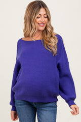 woman wearing a purple oversized knit maternity sweater with balloon sleeves and a visible baby bump