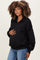 woman wearing a black maternity pullover with a zip front and holding her baby bump