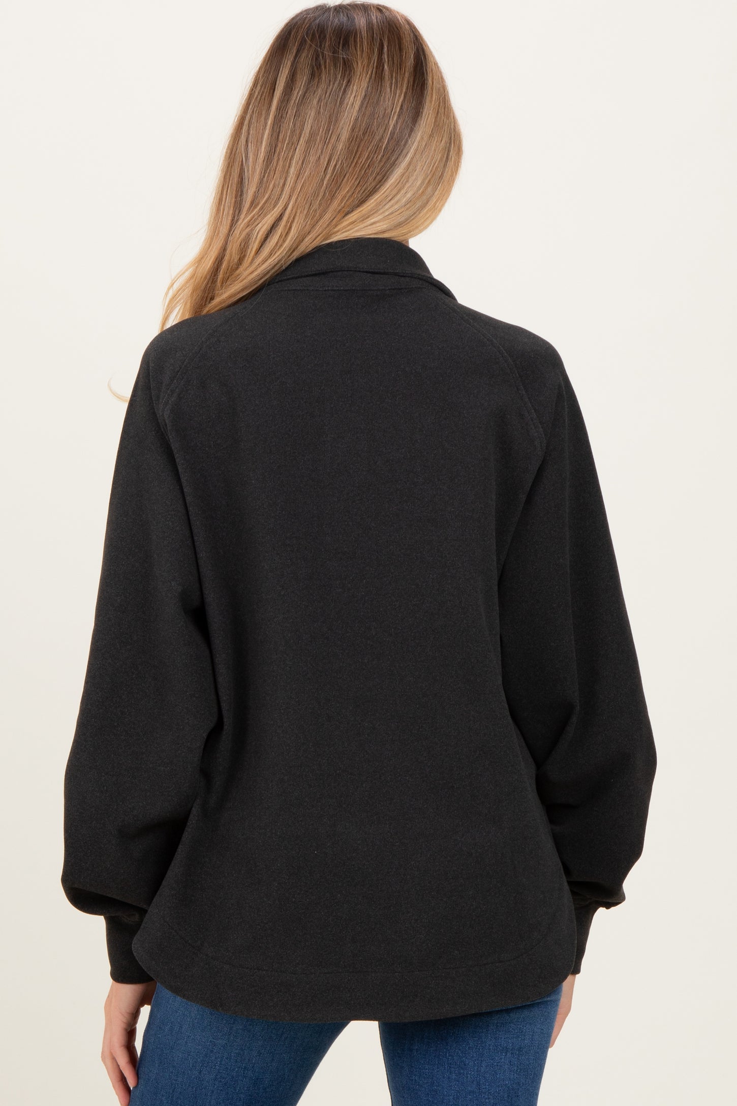 woman wearing a black maternity cardigan with oversized sleeves, displaying a relaxed fit from the back