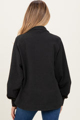 woman wearing a black maternity cardigan with oversized sleeves, displaying a relaxed fit from the back