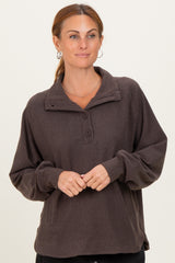 woman wearing a dark brown fleece pullover with a buttoned neckline and long sleeves