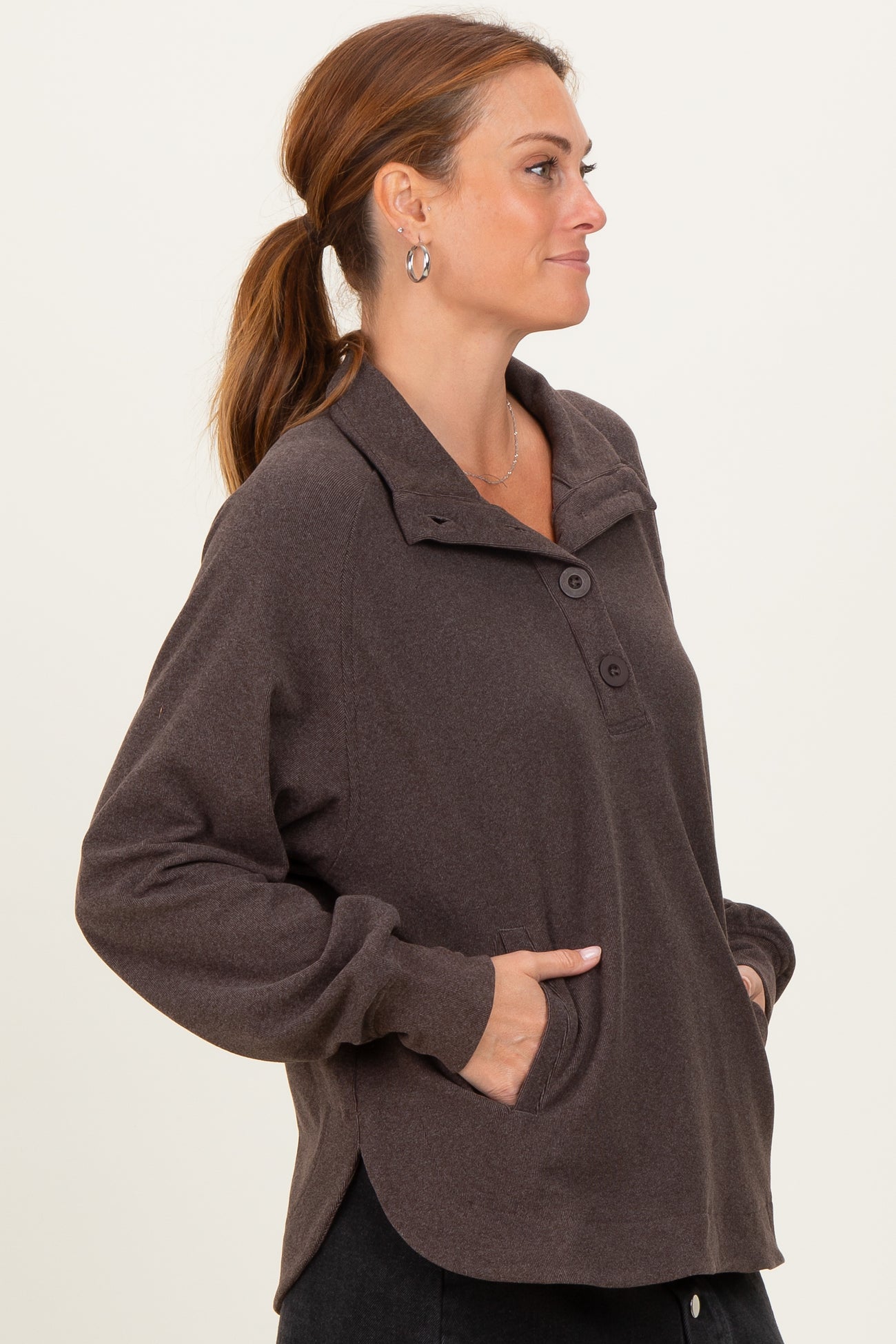 woman wearing a dark brown long sleeve pullover with a collar and side pockets