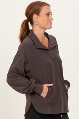 woman wearing a dark brown long sleeve pullover with a collar and side pockets