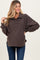 woman wearing a brown fleece maternity pullover with a collar and button details, showing a baby bump