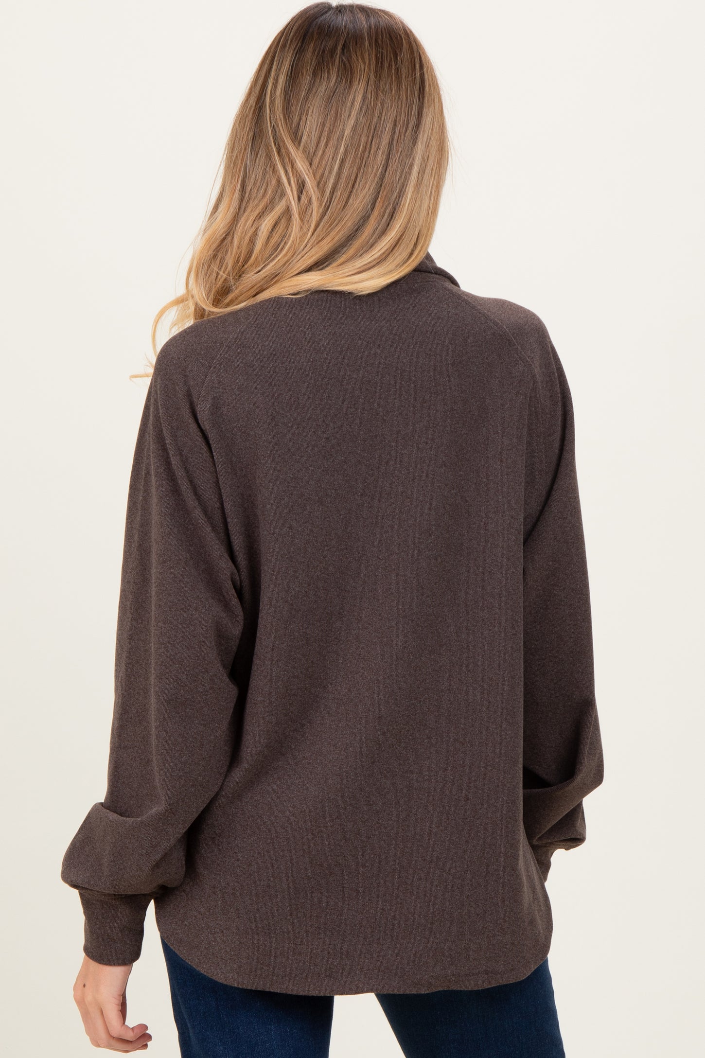 woman wearing a brown maternity pullover with long sleeves, shown from the back
