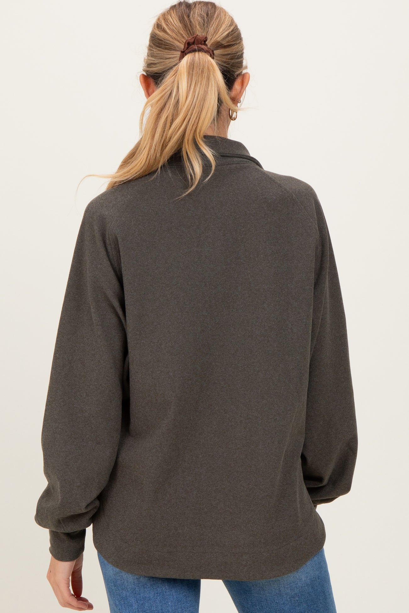 woman wearing a dark gray maternity top with long sleeves and a relaxed fit, showing the back view